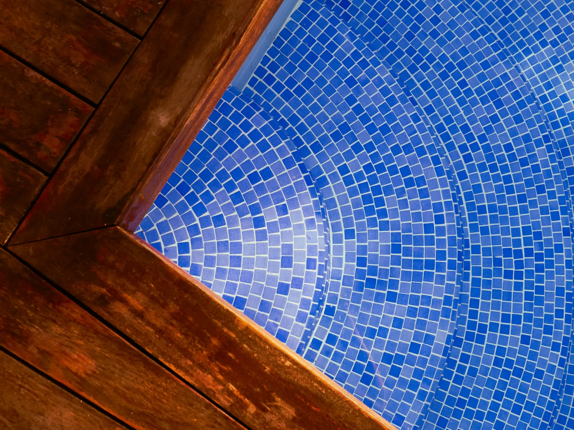 Blue mosaic tile at the waterline of an existing pool
