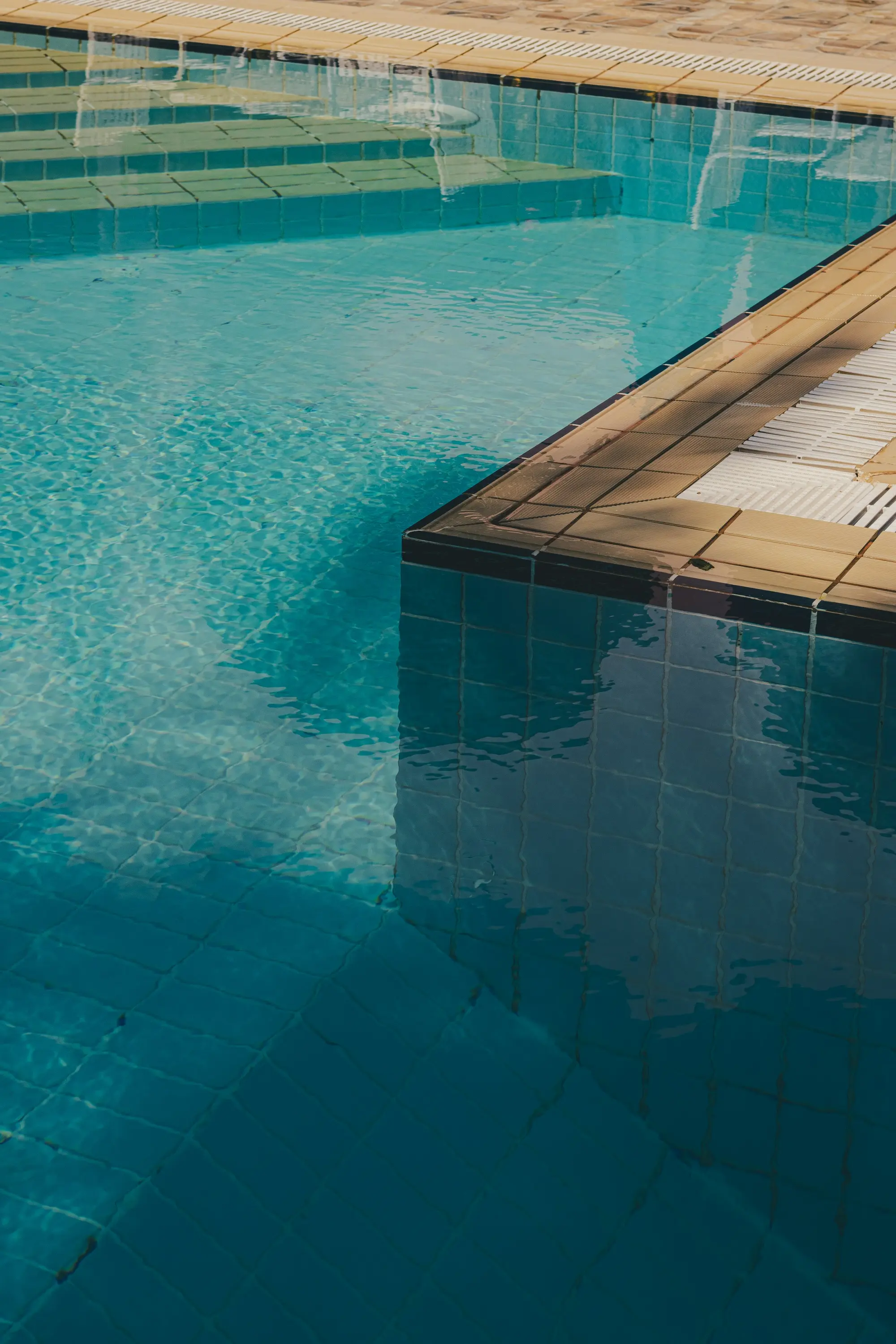 Clear water over blue tile and pool steps